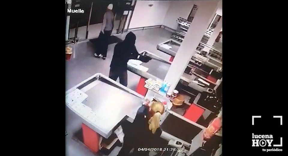 Fotograma del robo en el que puede observarse a los dos atracadores, uno de ellos con una pistola en la mano, y la cajera que le hace frente. Fotograma del robo en el que puede observarse a los dos atracadores, uno de ellos con una pistola en la mano, y la cajera que le hace frente.