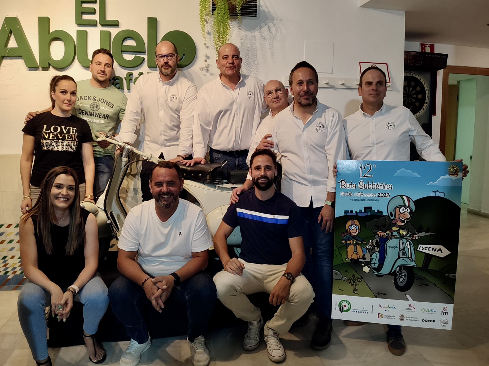 Miembros del Vespa Club Lucena con el cartel anunciador de la XII Ruta Subbética en Vespa