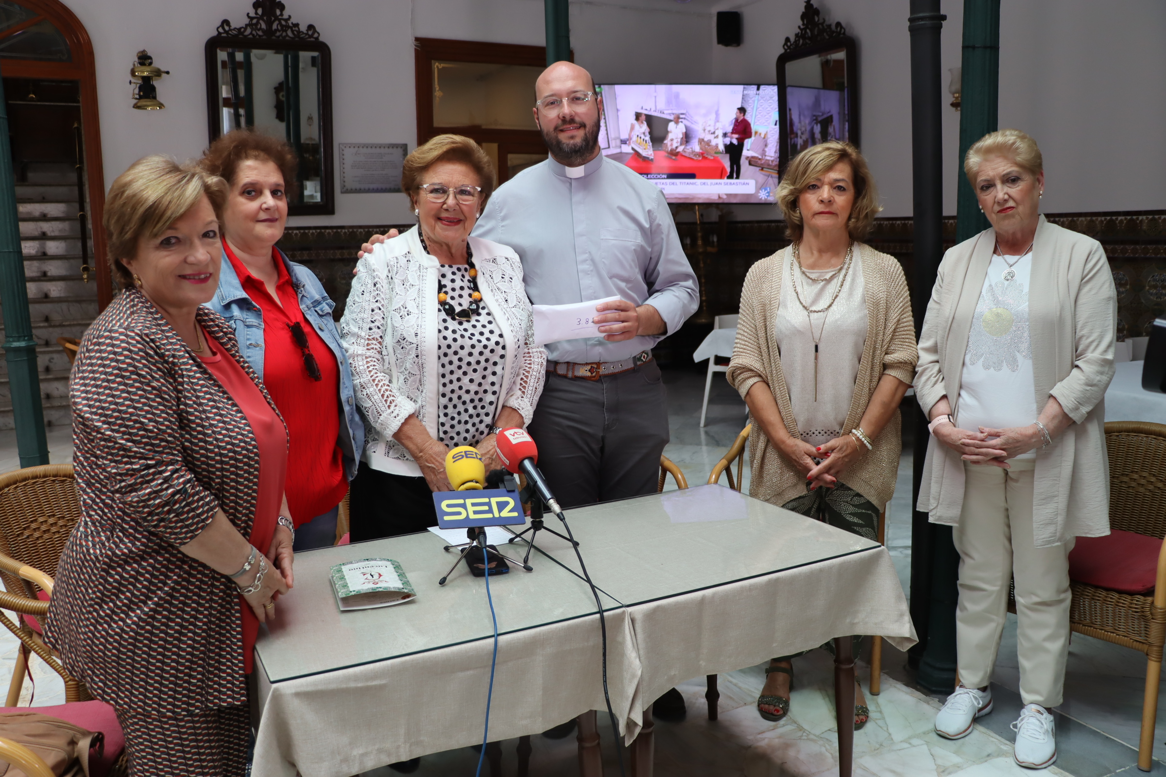 Entrega al párroco de El Carmen, Eugenio Bujalance, del dinero recaudado por la asociación Mujeres en Igualdad