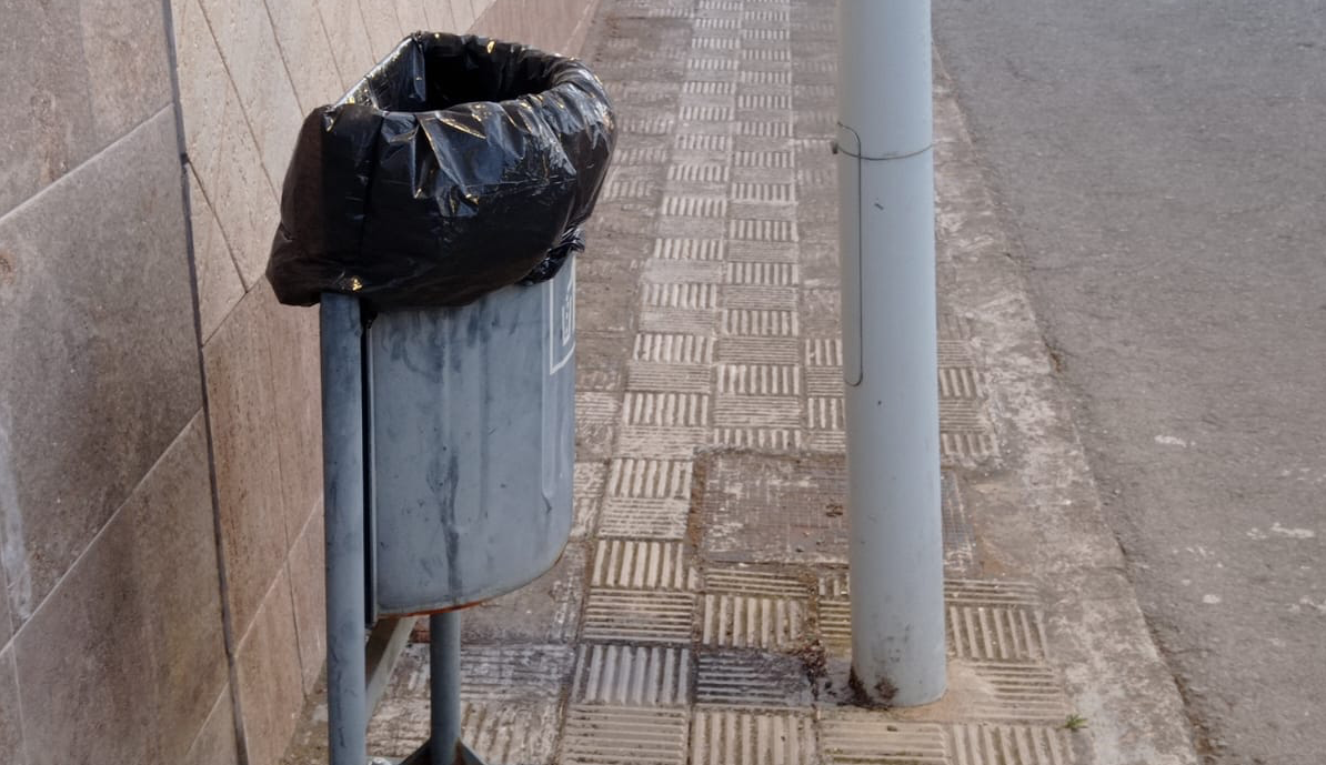 Papeleras colocadas junto a farolas en un acerado estrecho. Calle Las Margaritas