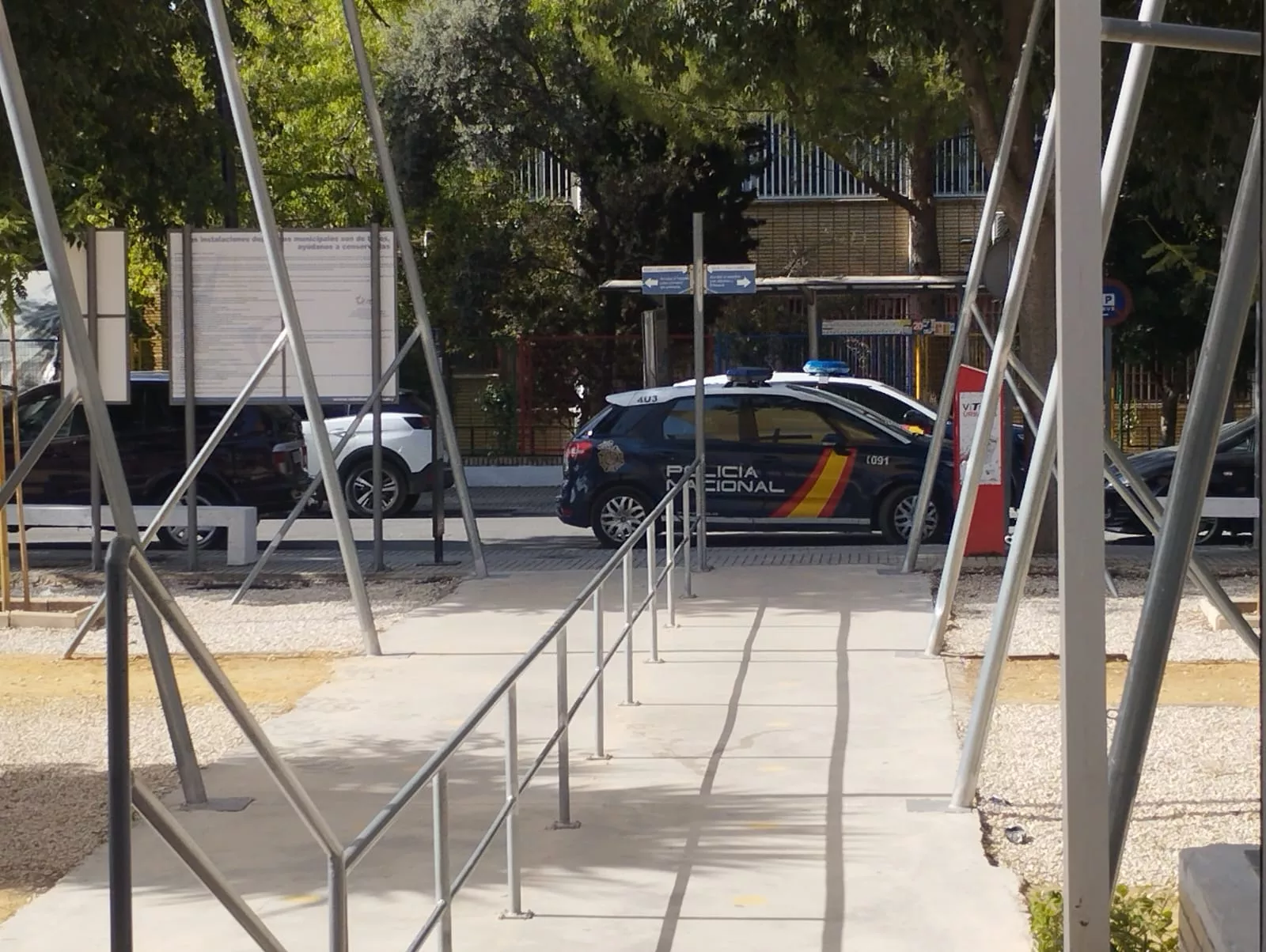 Vehículos de la policía nacional junto a la entrada de las piscinas