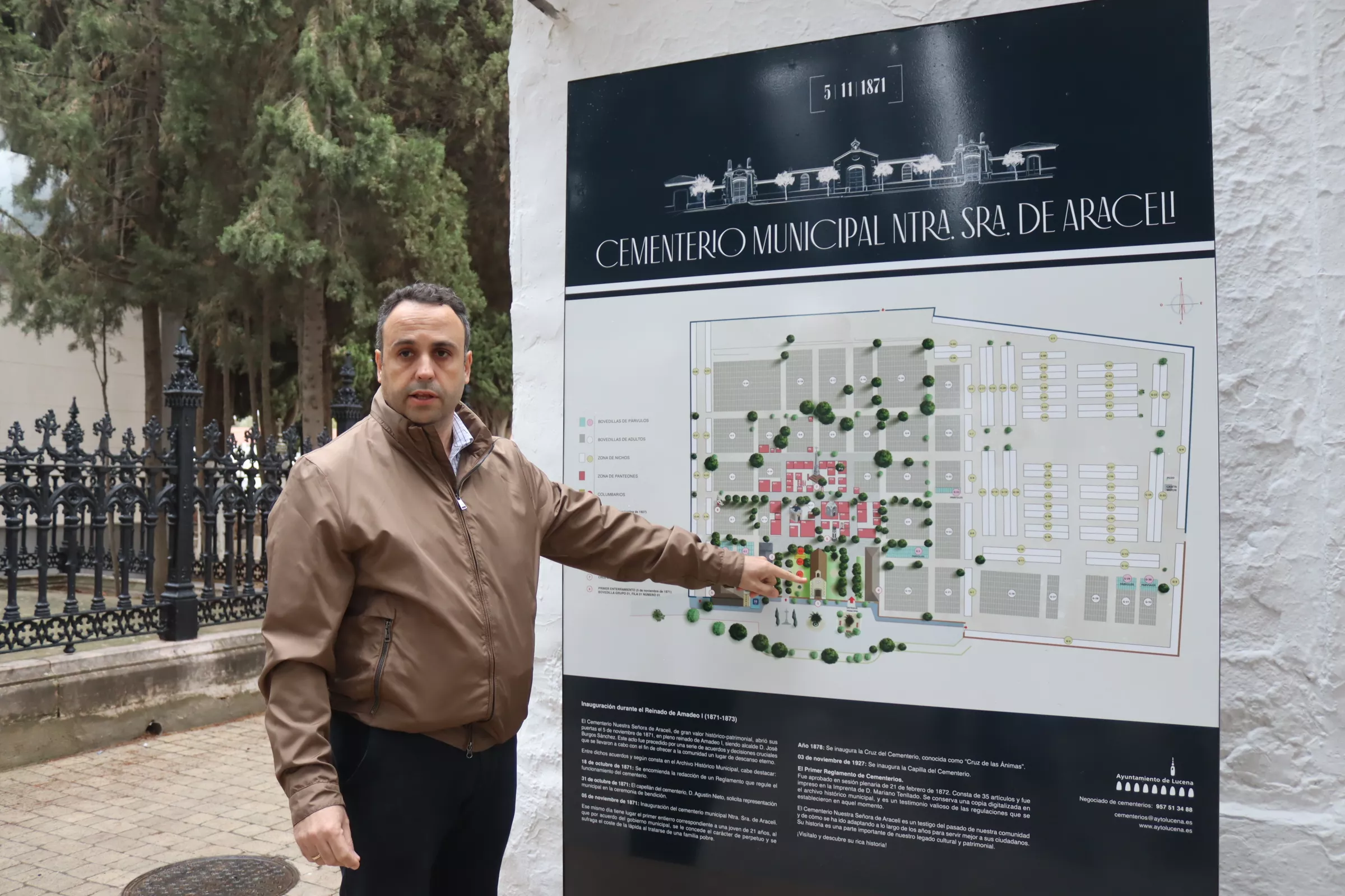 Javier Pineda junto al panel informativo instalado a la entrada del cementerio
