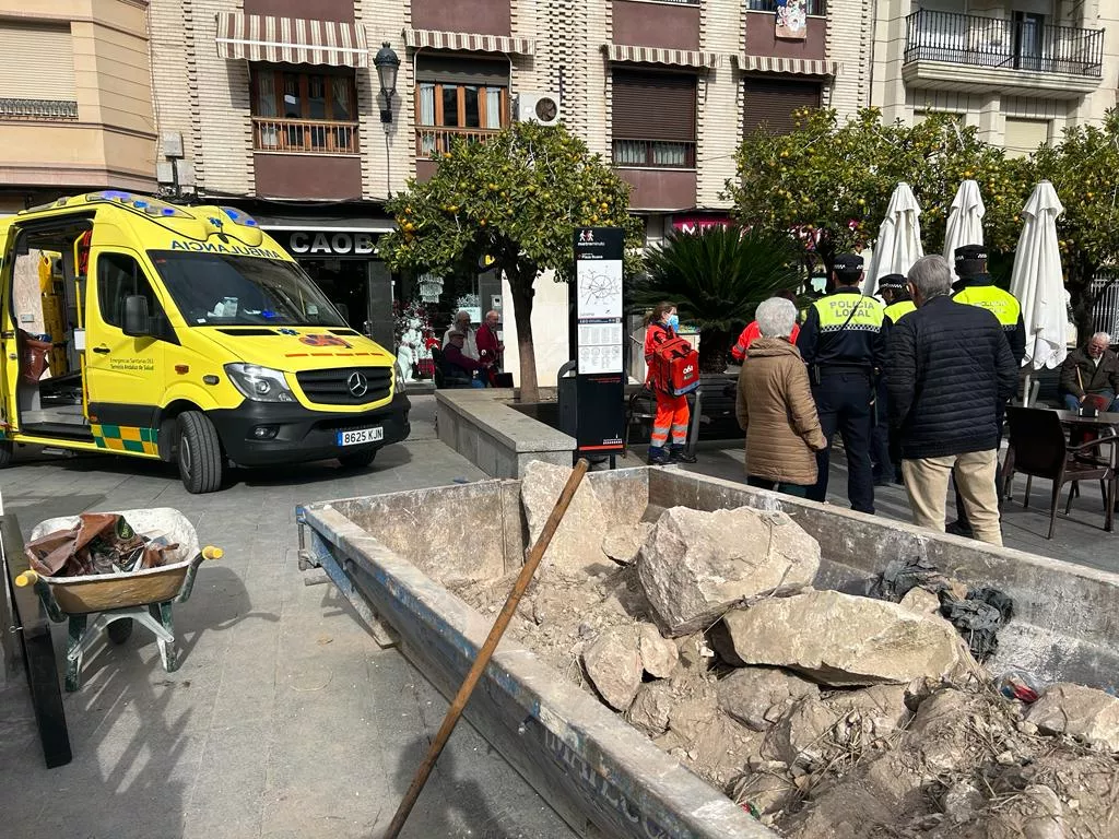 Sanitarios trasladan al hombre herido en la Plaza Nueva mientras varias personas observan los hechos