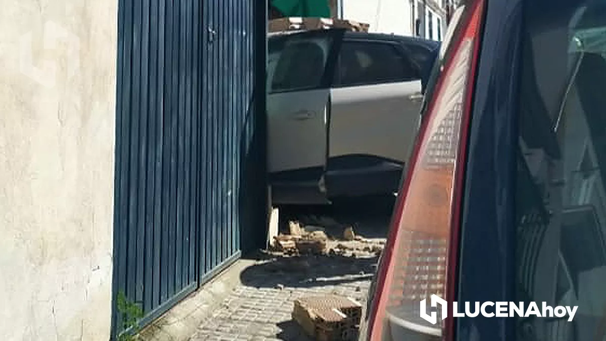 Una imagen del vehículo siniestrado con algunos cascotes del muro que ha derribado tras la colisión