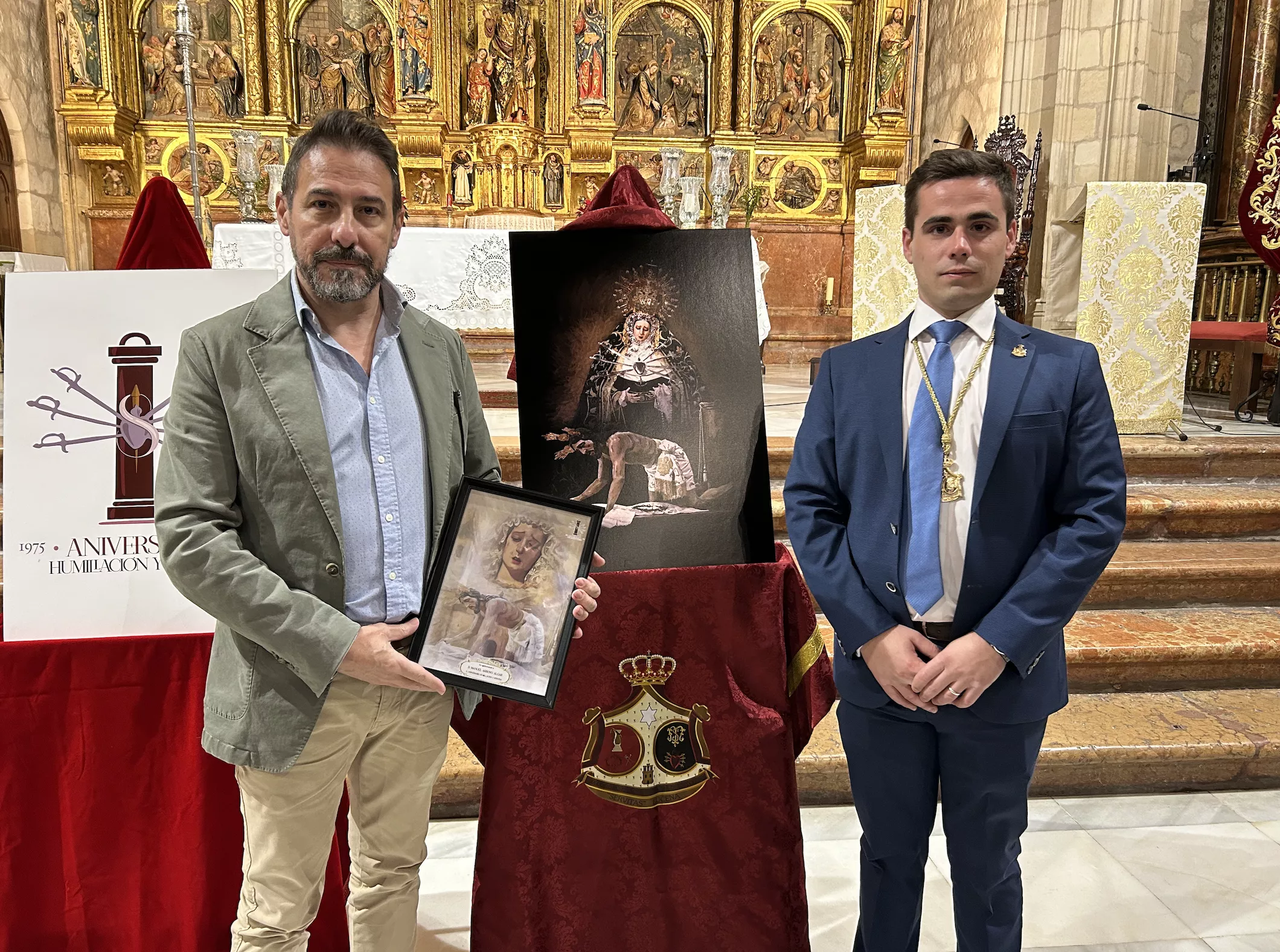 Manuel Arroyo, autor del cartel, junto a Francisco Jesús Bergillos, hermano mayor, junto al cartel anunciador del 50 Aniversario Fundacional
