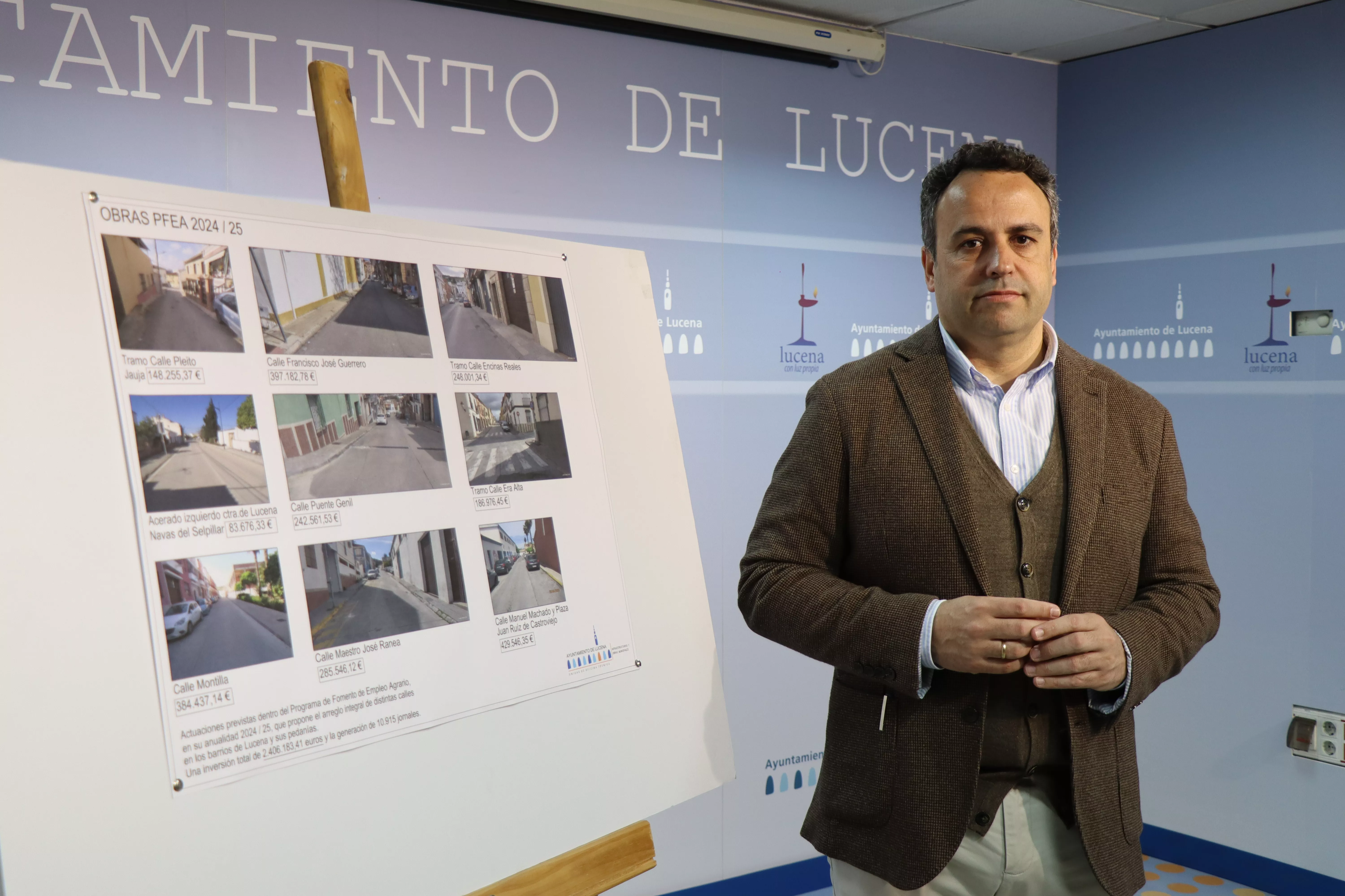 Javier Pineda junto al cartel descriptivo de las obras a realizar