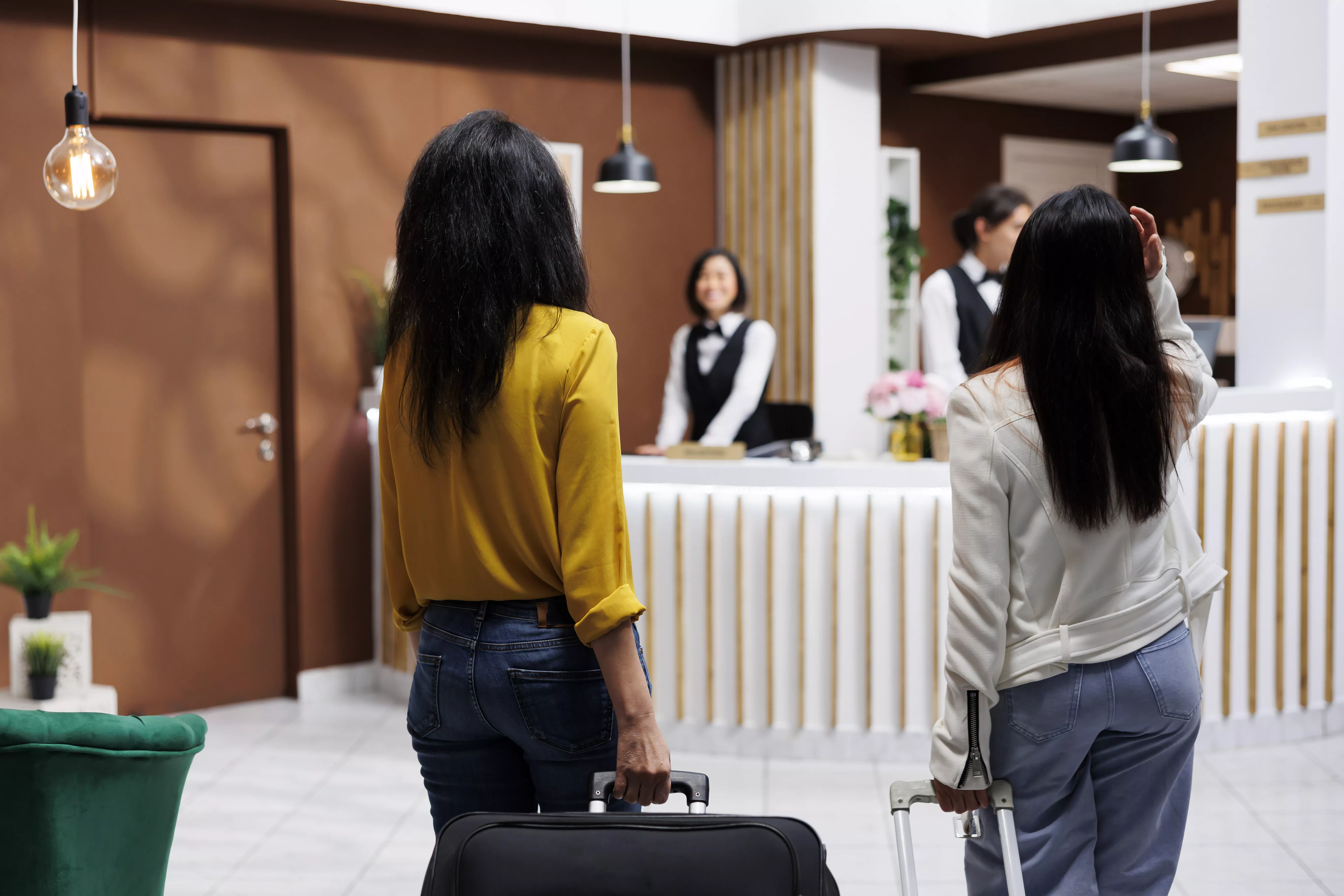 Dos turistas en la recepción de un hotel. Foto: Freepik