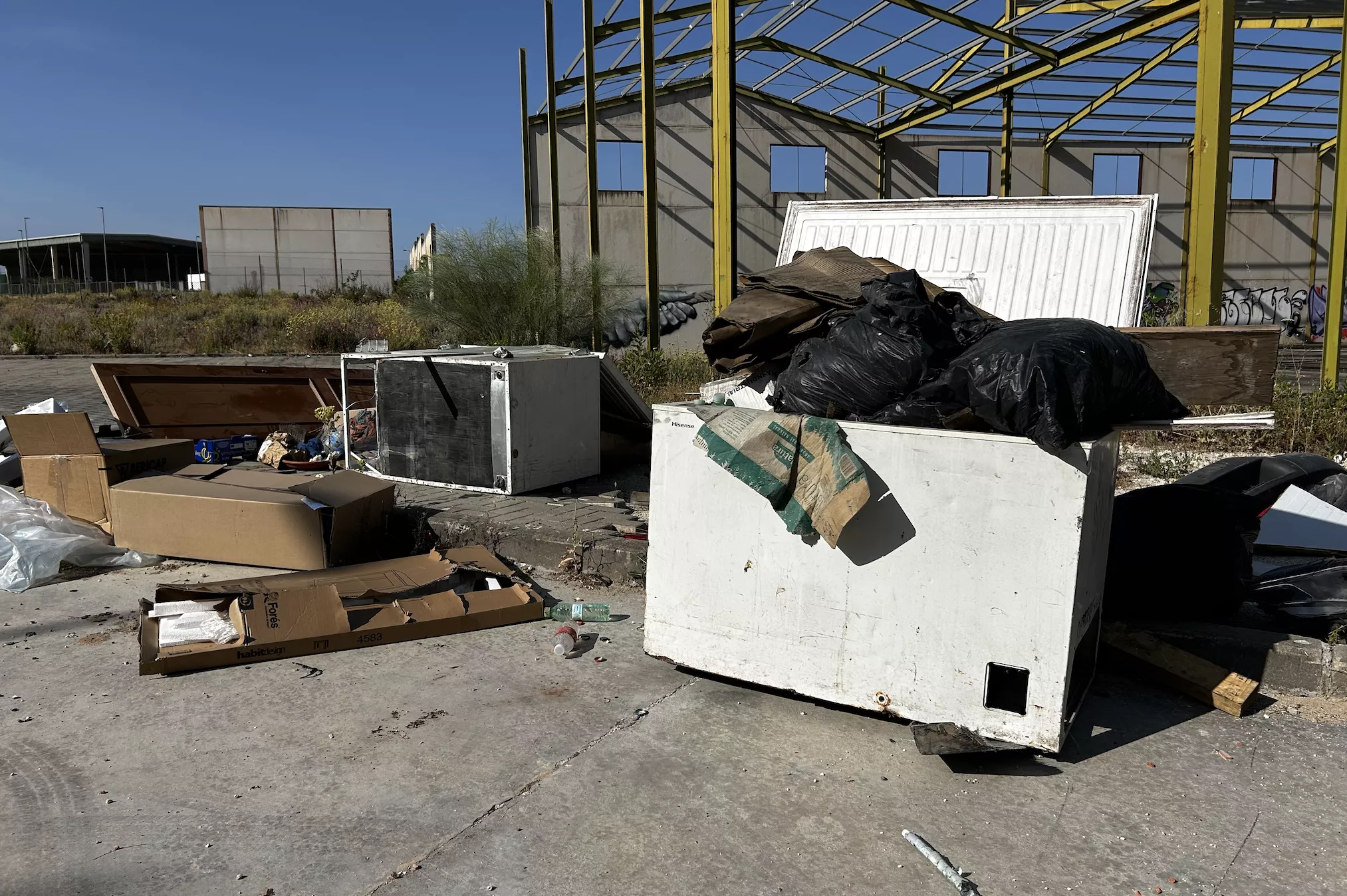 Restos de obra, muebles o congeladores se acumulan en el acerado de una de las calles del parque empresarial