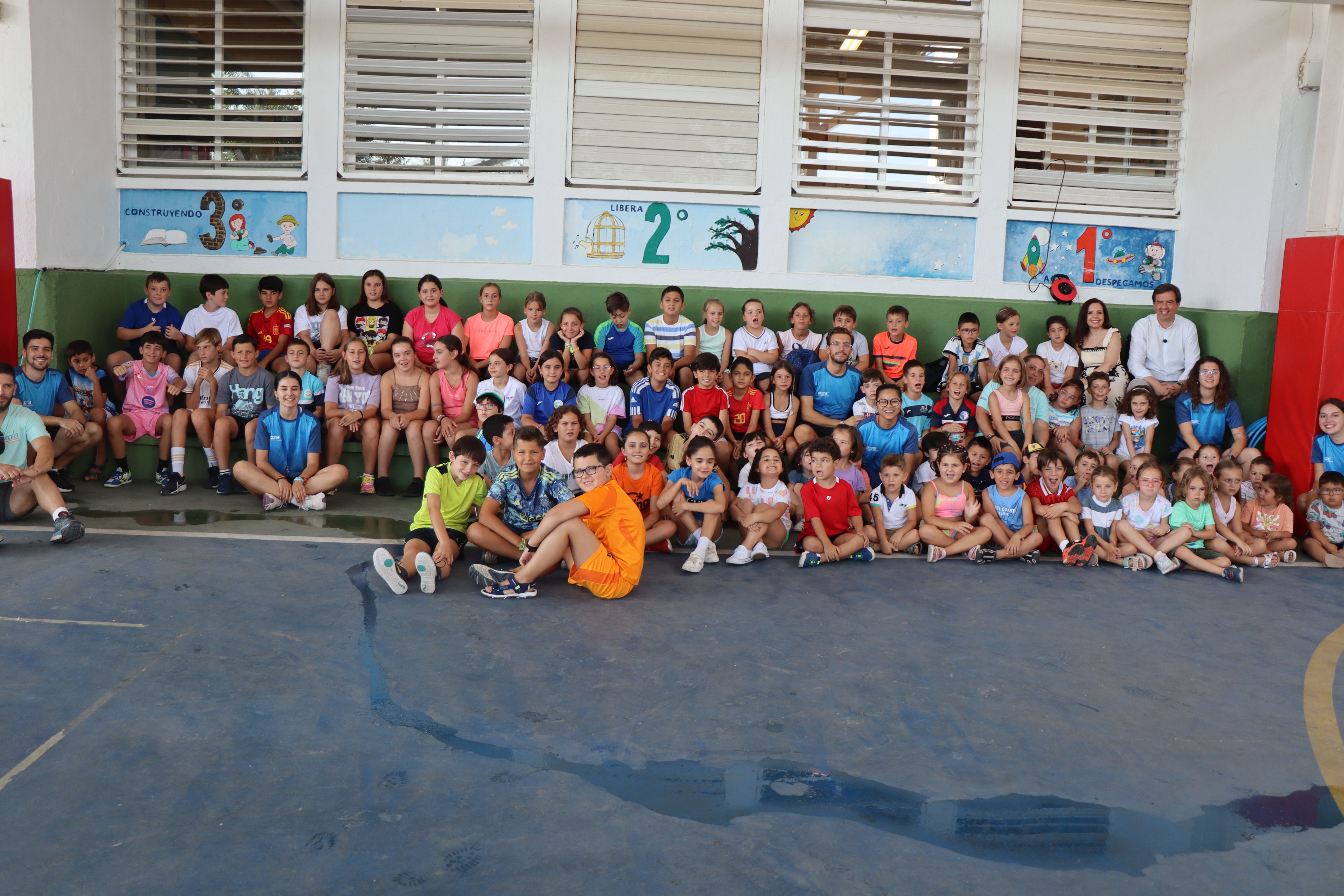 Autoridades, monitores y niños y niñas participantes en la ludoteca de verano del colegio San José de Calasanz