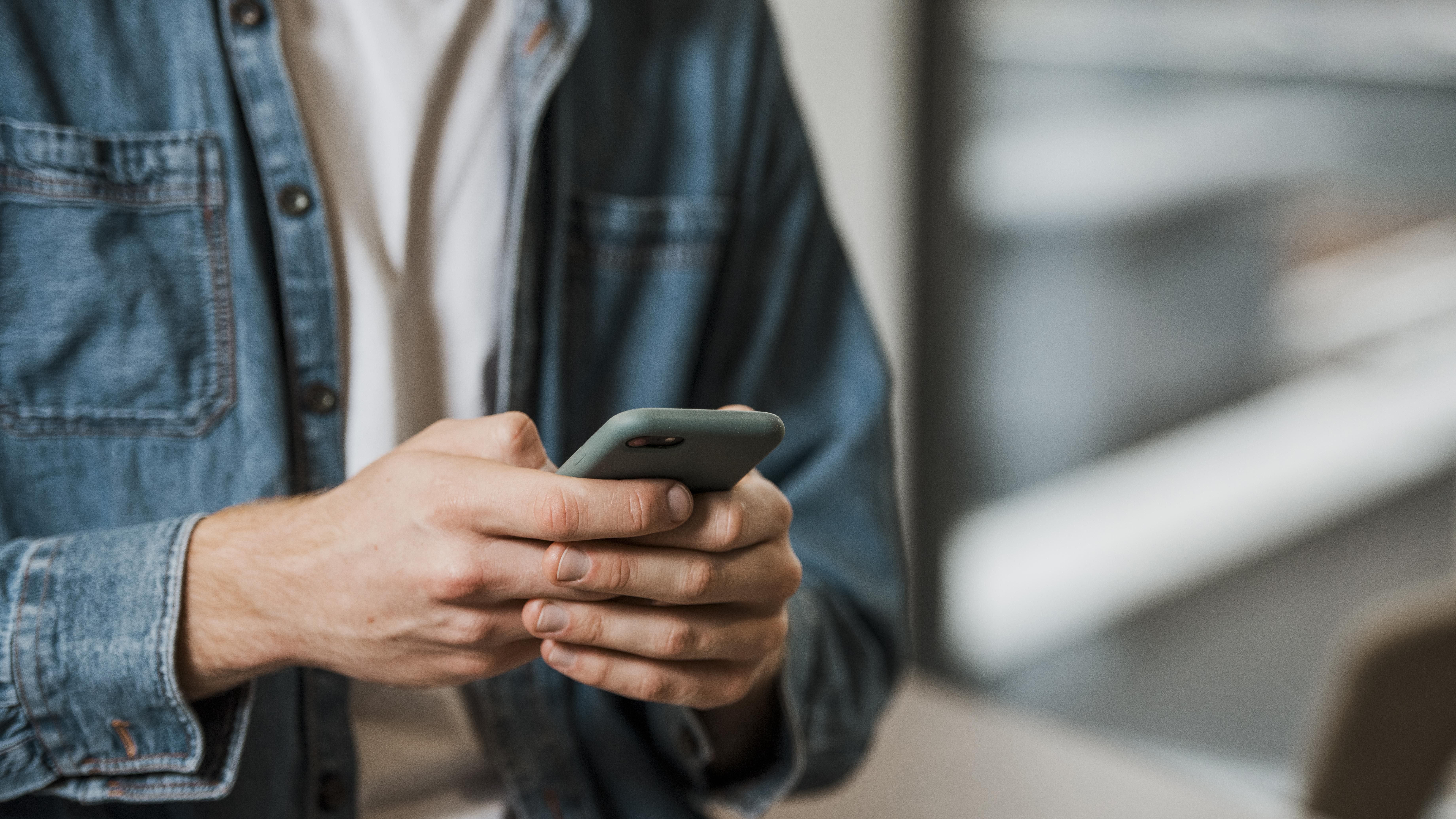 Una persona consulta su teléfono móvil. Foto: Freepik