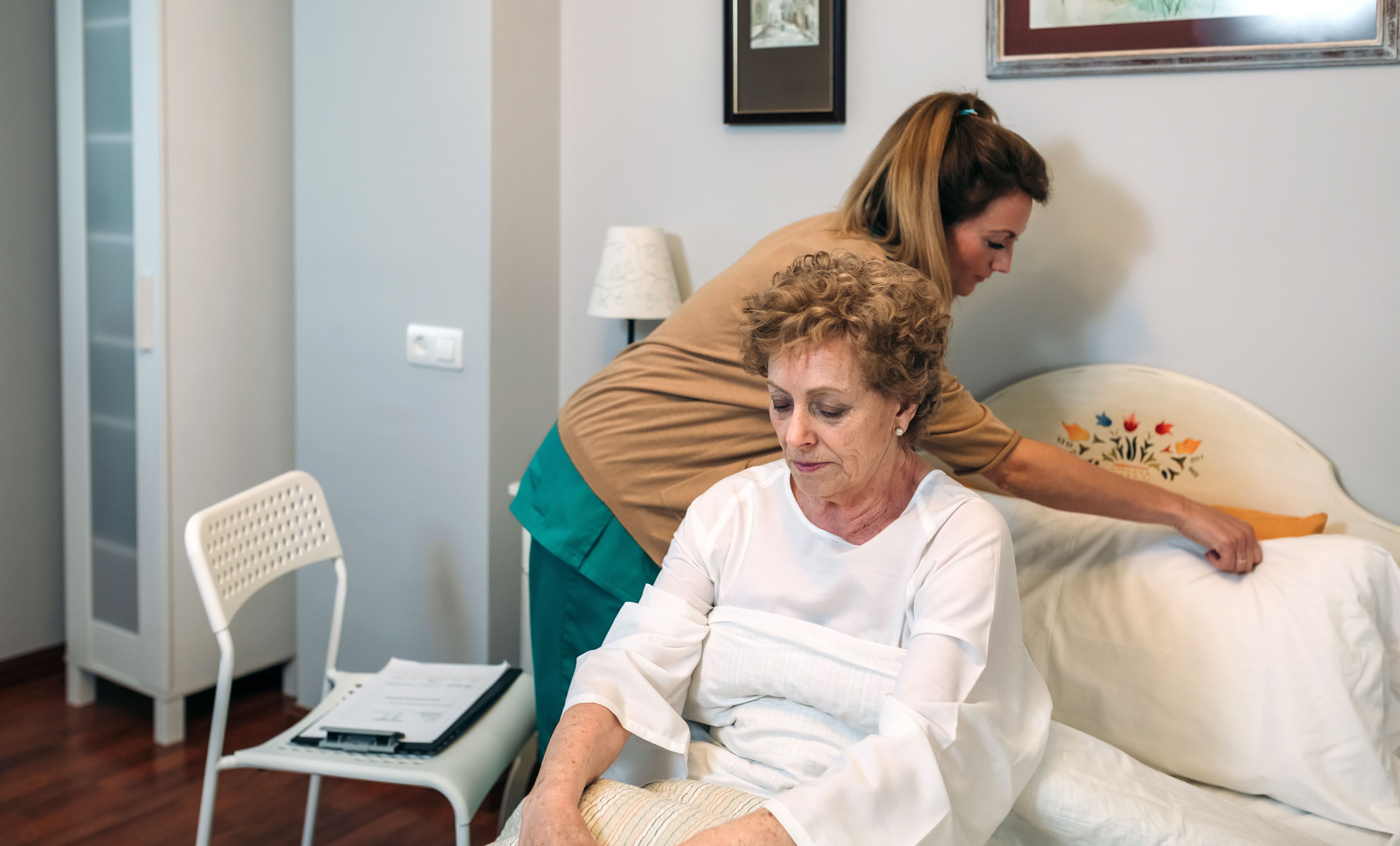 Cuidadora acomodando a una paciente anciana