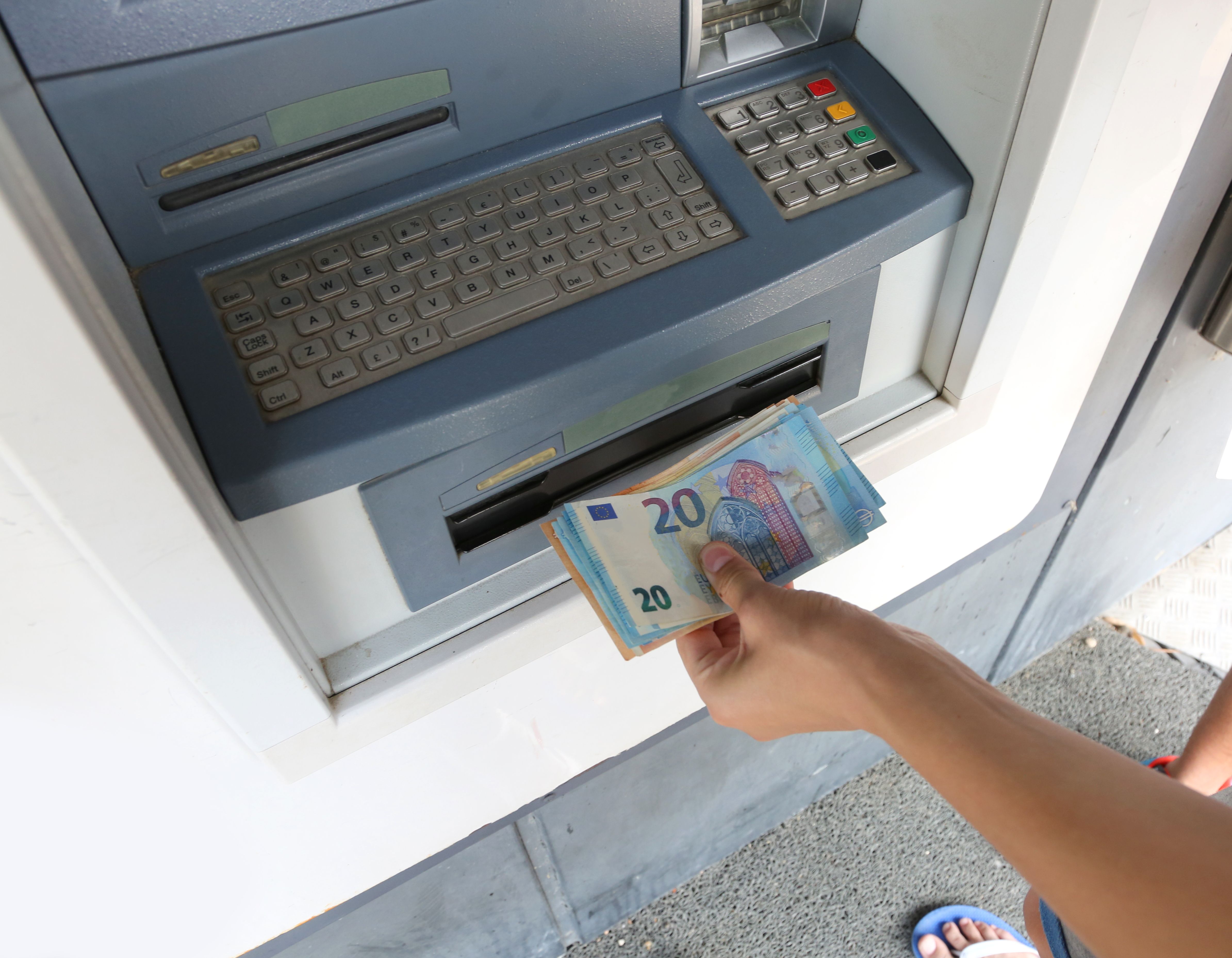 Una persona extrae dinero de un cajero. Foto: Freepik