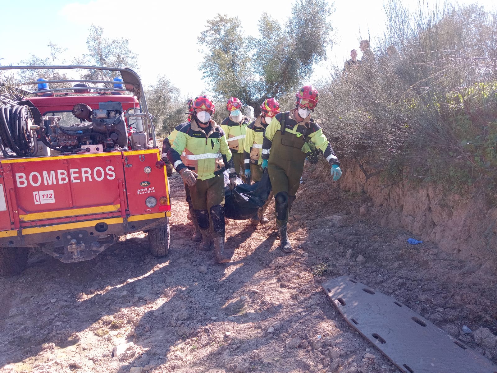 Los bomberos proceden al traslado del cadáver. 