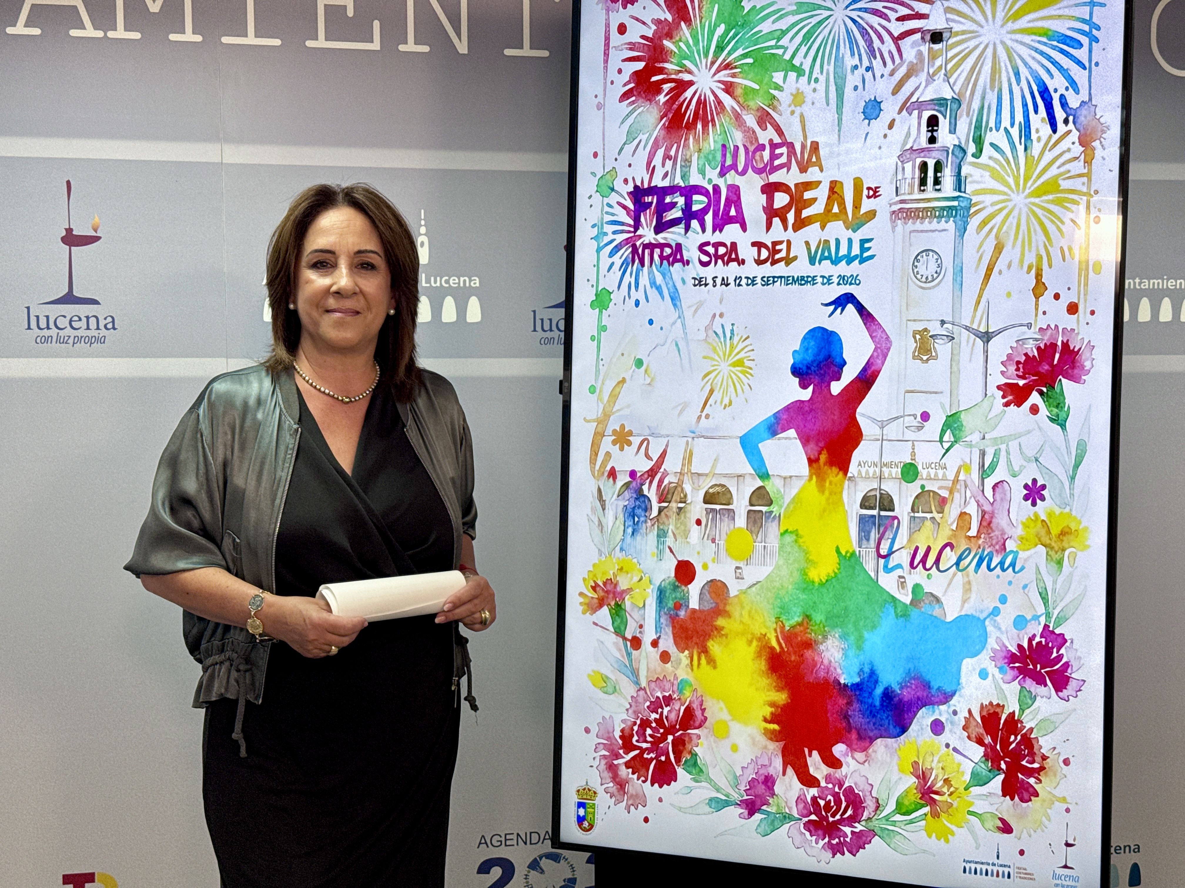La edil de Fiestas, Araceli Rodríguez, junto al cartel anunciador de la Feria Real de Ntra. Sra. del Valle 2026.