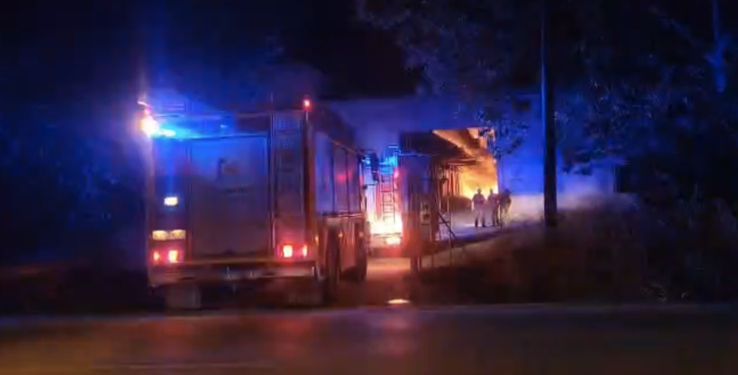 Momento de la llegada de las diferentes dotaciones de bomberos al incendio declarado esta noche en un conjunto de naves industriales situadas en carretera de Rute.