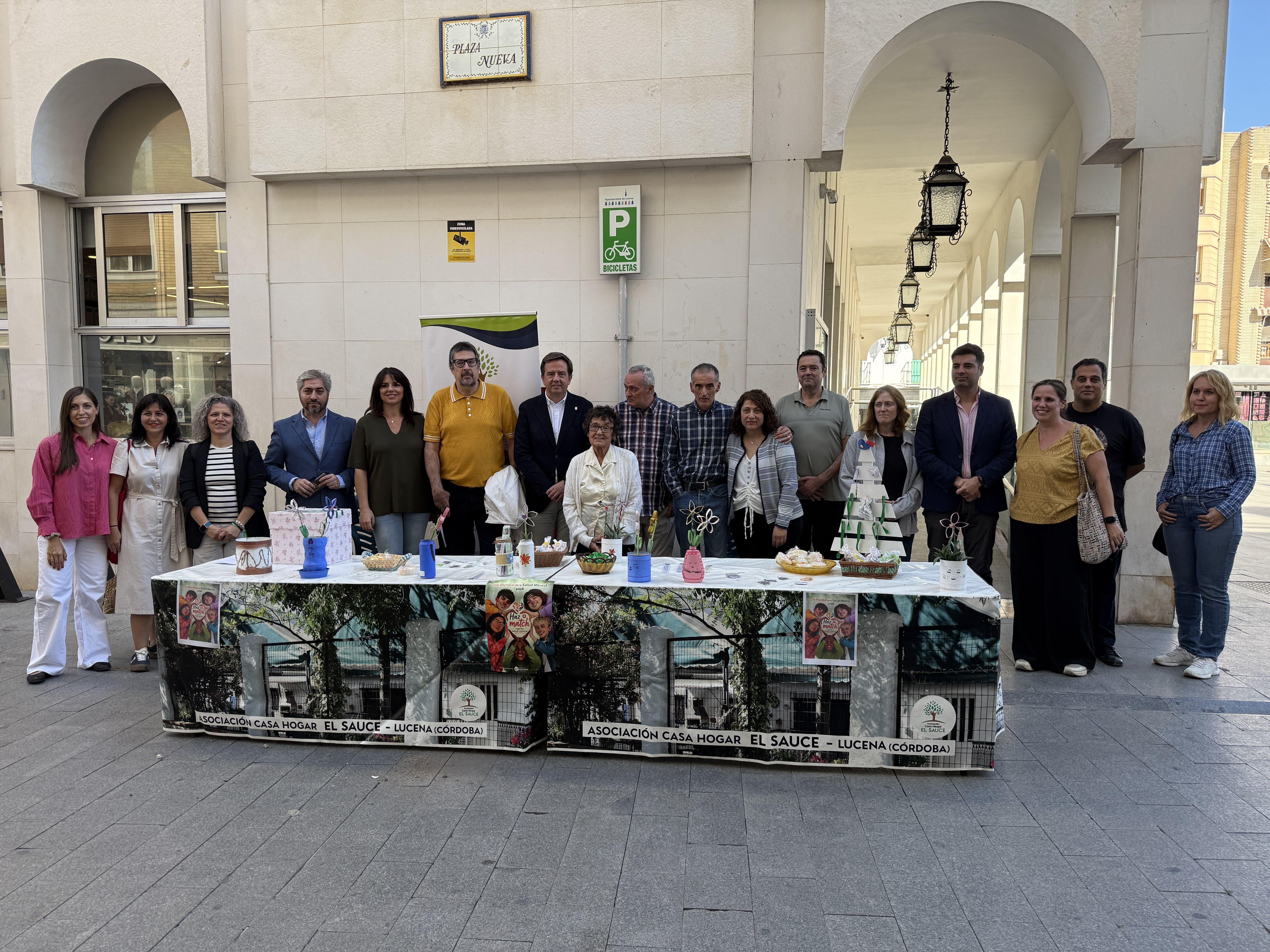 Usuarios, voluntarios y representantes municipales, junto a la mesa informativa instalada por El Sauce con motivo del Día Mundial de la Salud Mental.