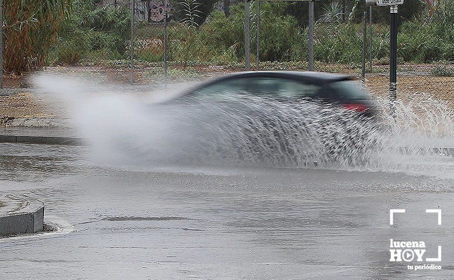  Un coche atraviesa la lámina de agua embolsada en la rotonda del Puente Córdoba 