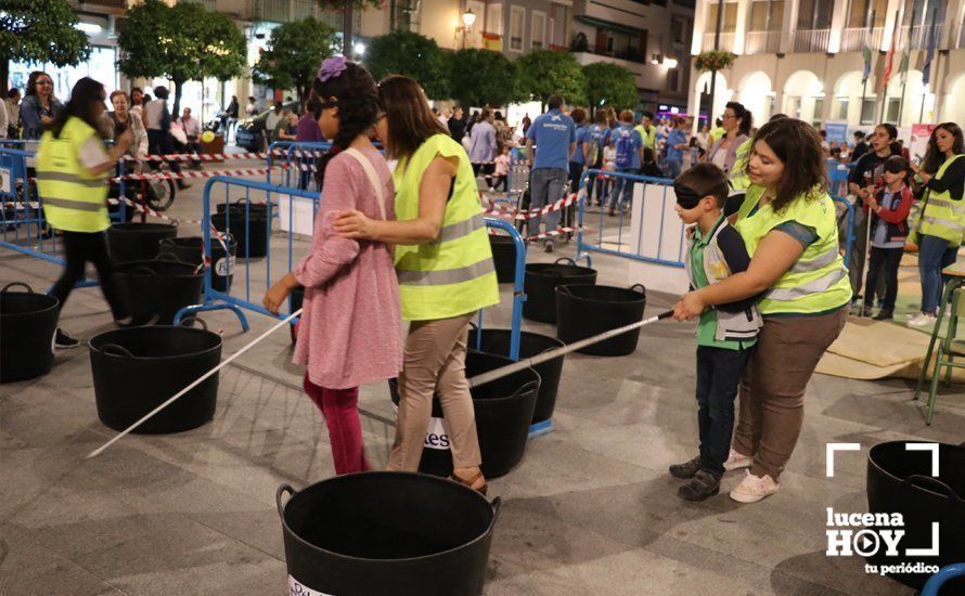  Dos niños con los ojos vendados intentan moverse por un circuito de obstáculos con ayuda de un bastón 