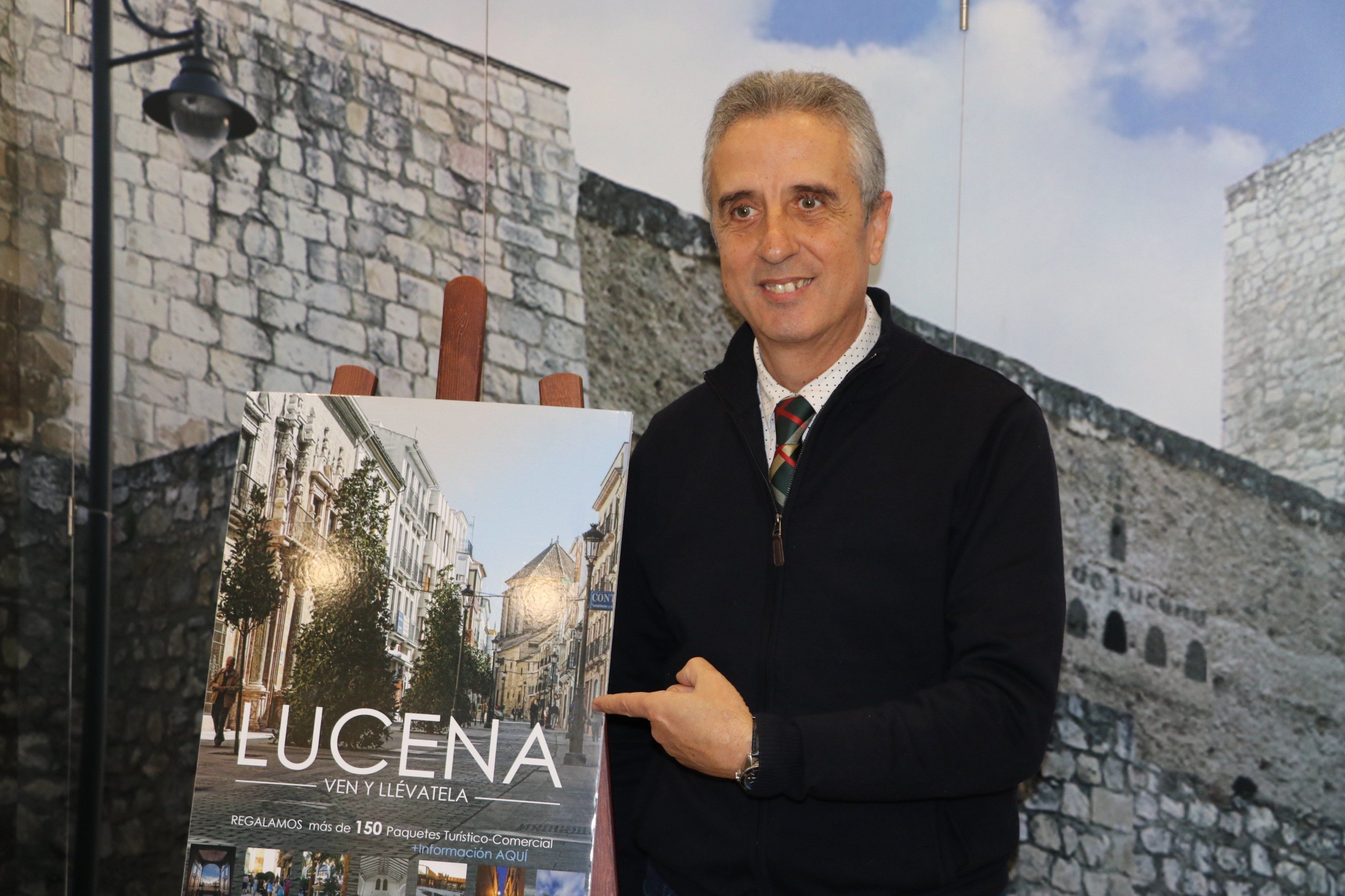  Juan Pérez junto a la imagen promocional de la campaña 'Lucena, ven y llévatela' 