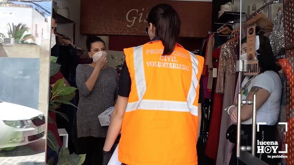  Una voluntaria de Protección Civil reparte mascarillas en un comercio lucentino esta mañana 