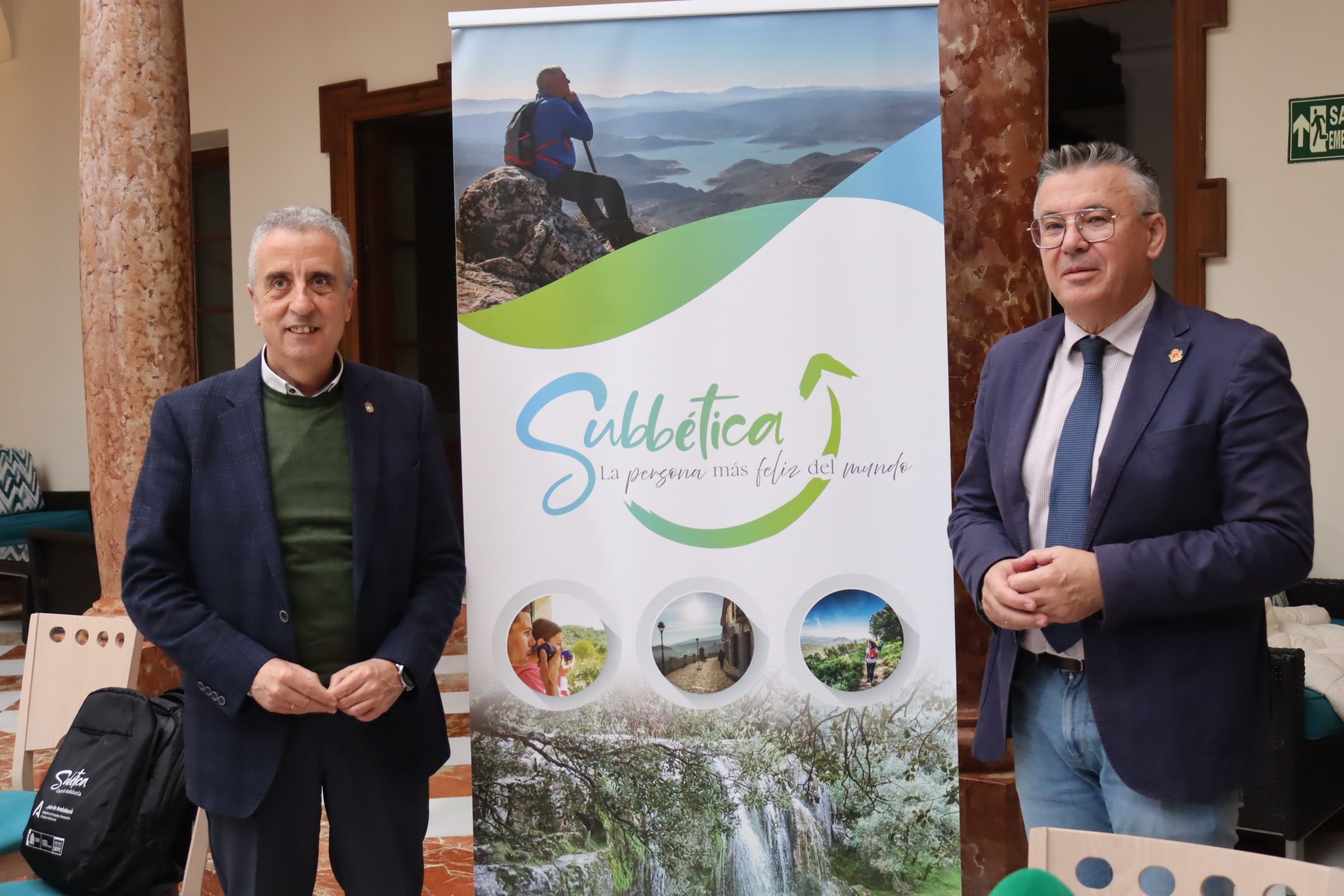 Juan Pérez y Lope Ruiz junto a la imagen de campaña de la Subbética en Fitur 2023