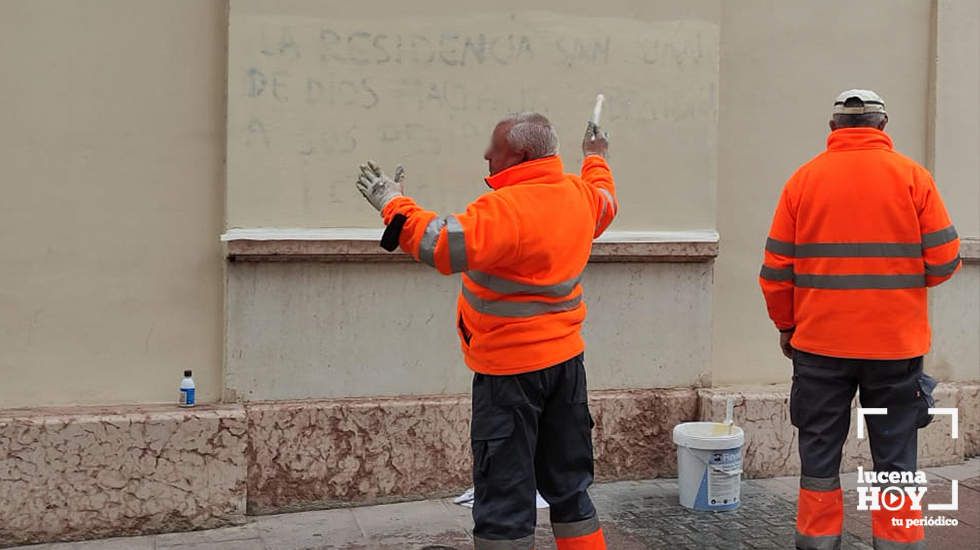  Dos trabajadores cubren una de las pintadas contra la residencia en la calle El Agua 