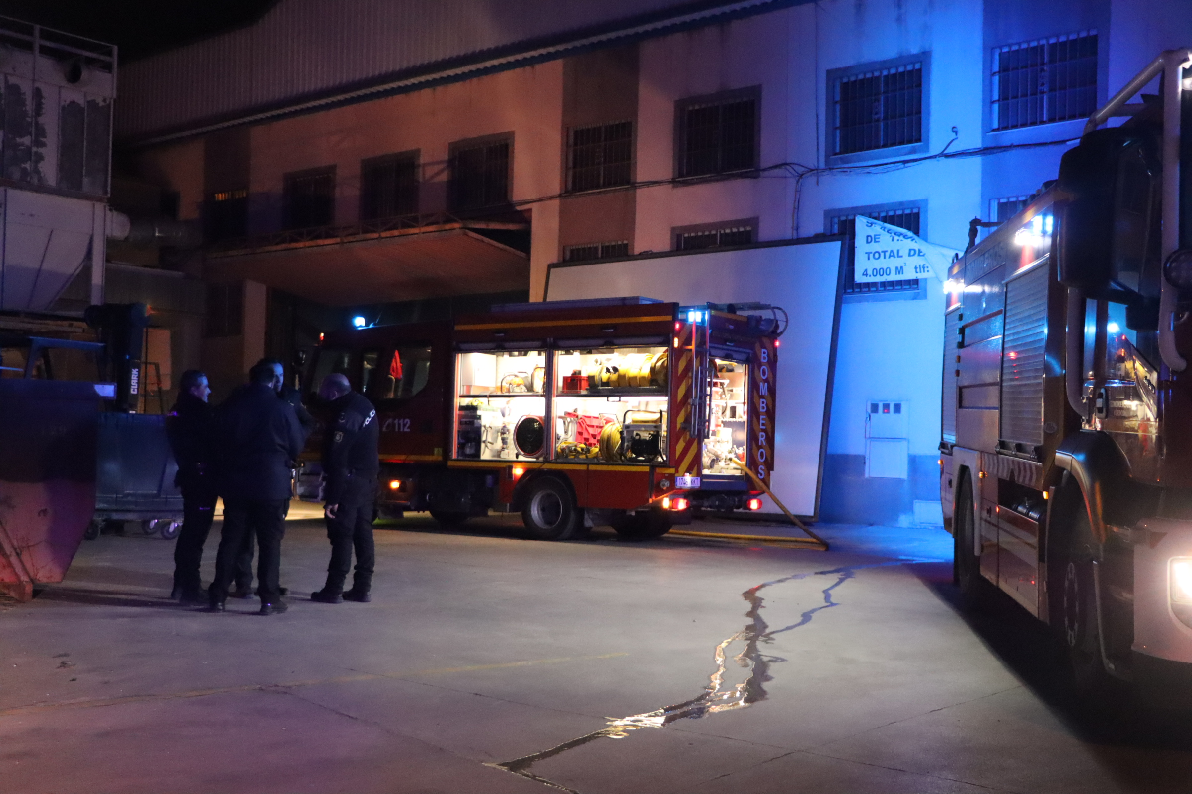 Efectivos del Parque de Bomberos y policía local y nacional colaboran en la extinción del incendio en la nave afectada