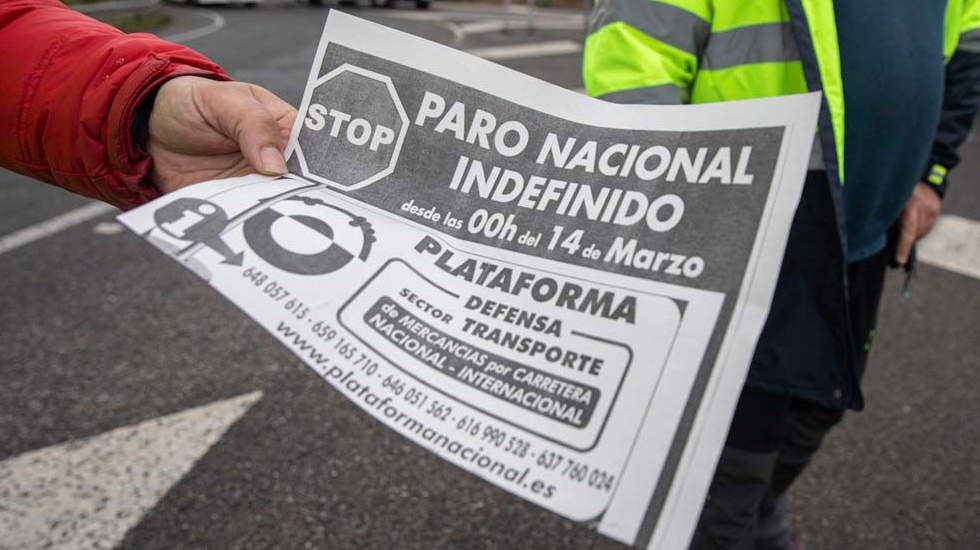  Un transportista muestra una hoja informativa sobre el paro en un piquete. 